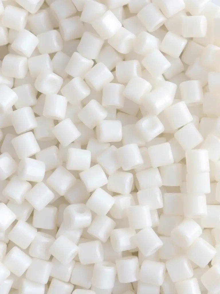 A close-up image of plastic pellets made from recycled materials, showcasing their uniform size and color, ready for use in manufacturing new building products by RePolyBuild International.